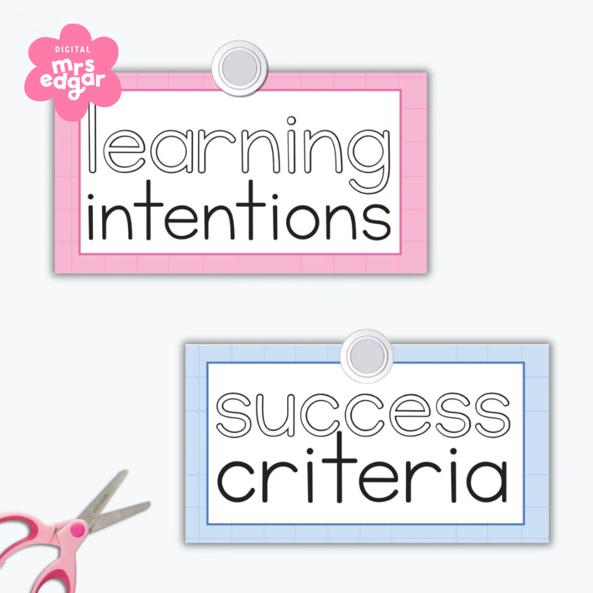 Two learning display signs for 'Learning Intentions' and 'Success Criteria' on pink and blue backgrounds. A pair of pink-handled scissors in the corner suggests a DIY classroom resource.