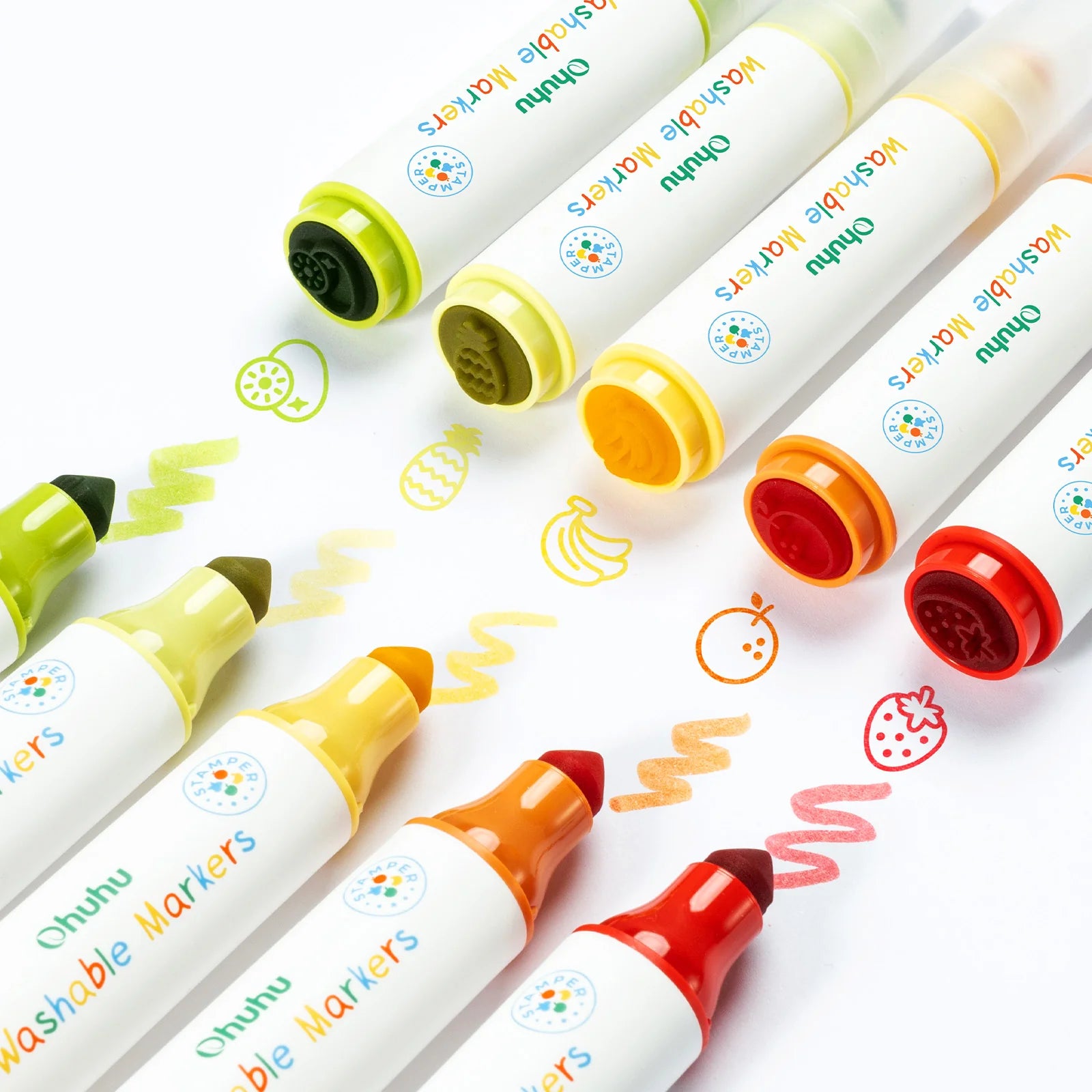 Close-up of kids’ washable markers in use, creating fruit stamps and squiggly lines.