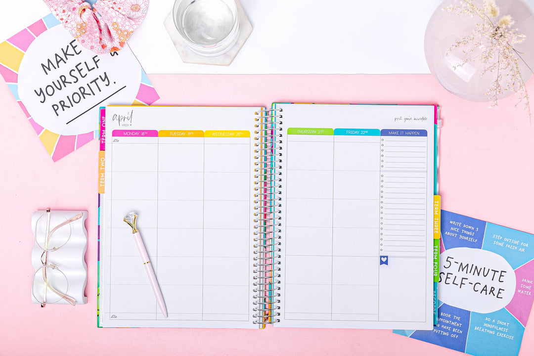 Open Mrs Edgar teacher planner showing a colour-coded weekly spread, styled flat lay on a pink background with self-care cards and a pen