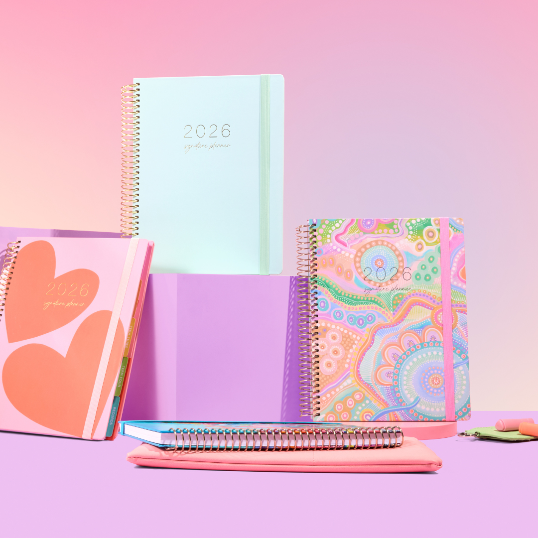 Aurora A5 notebook with pink, floral design by Amy Lockwood, with elastic closure, ribbon bookmarks, and a pen.