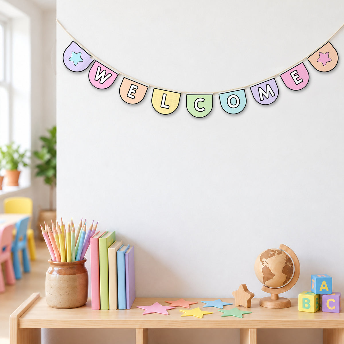 WELCOME spelled in swallowtail bunting with star pennants, strung across a classroom in soft Gentle colours