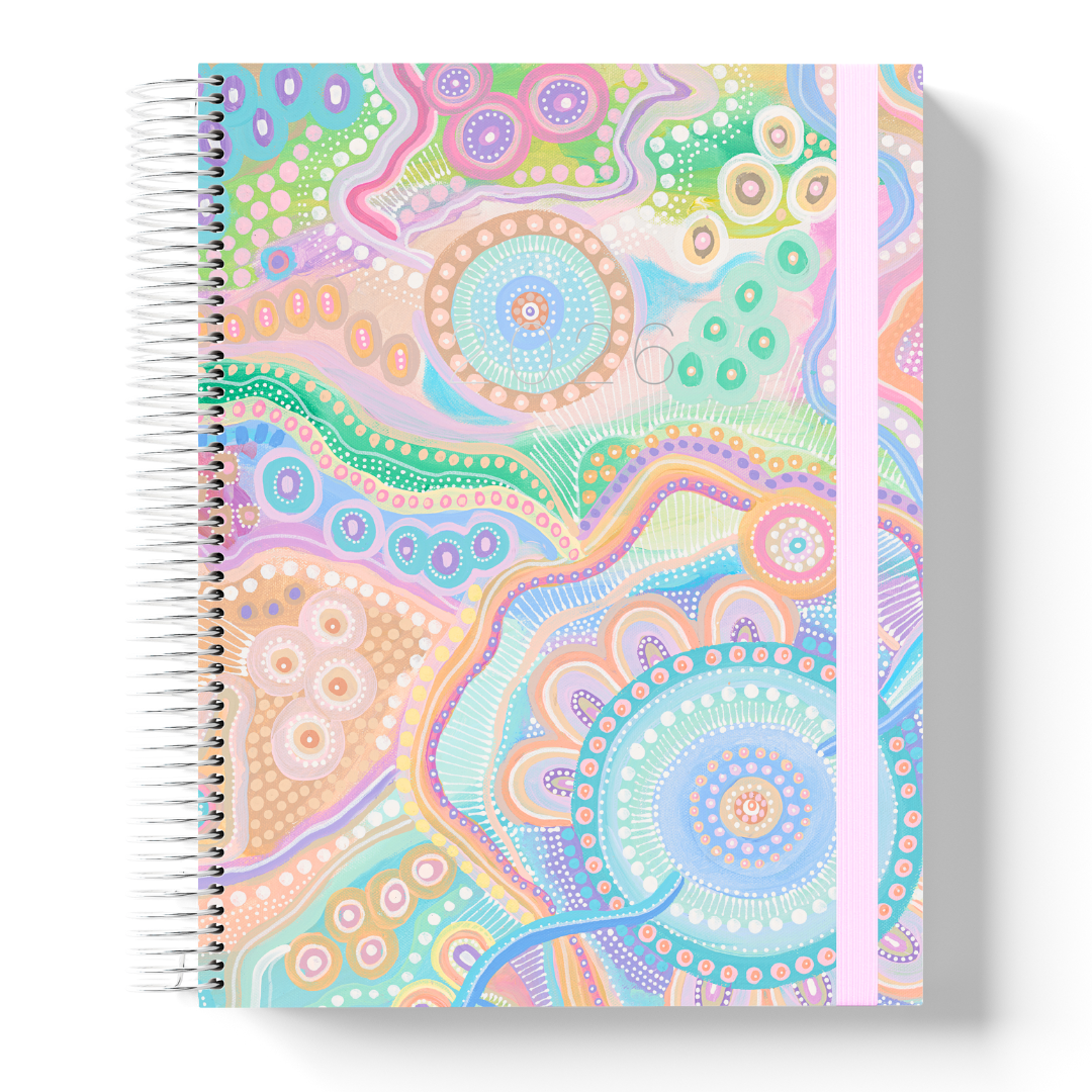 2026 teacher planner with pastel Indigenous artwork in soft pinks, greens, and blues, silver coil binding, and light pink elastic strap.