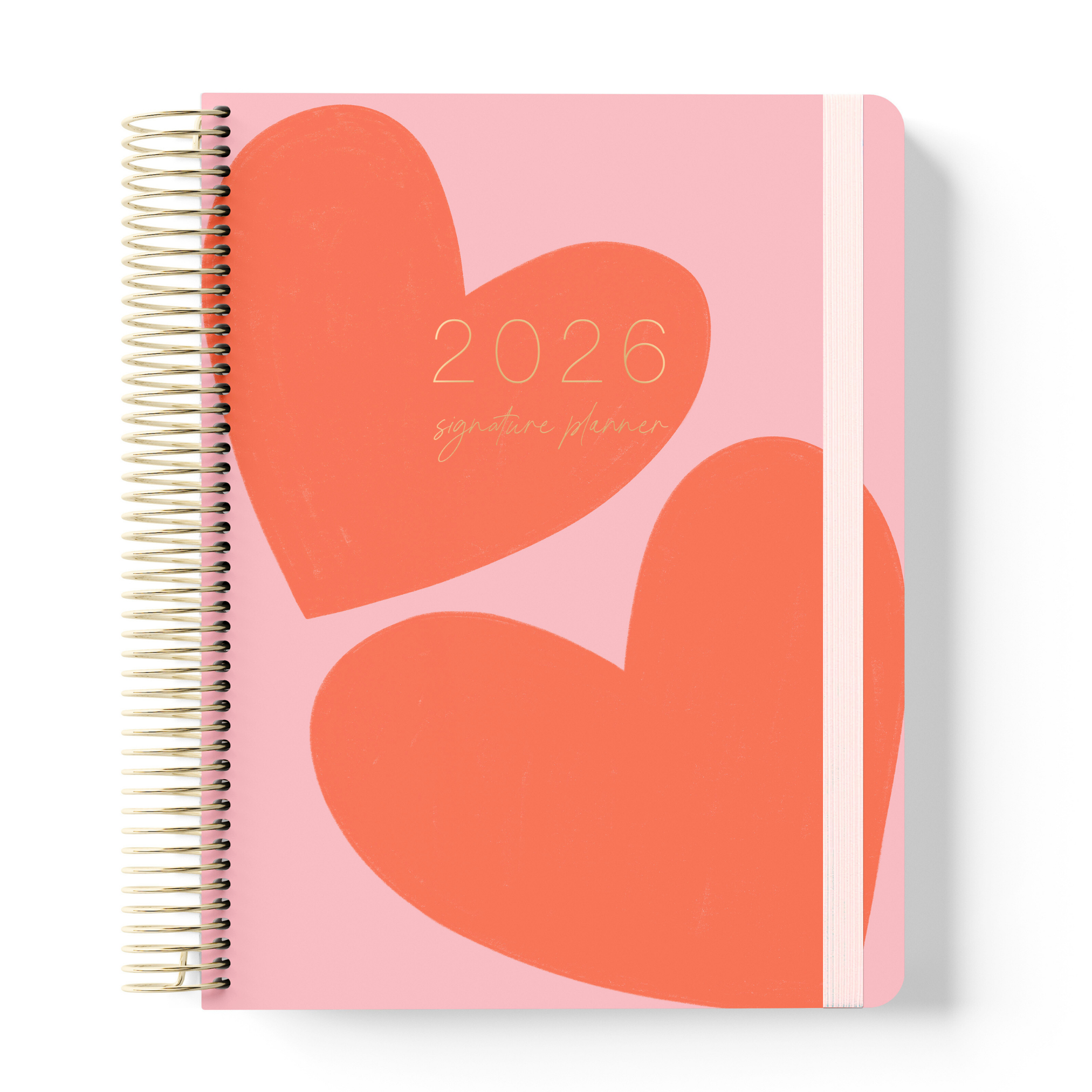 2026 teacher planner with a pink cover featuring two large red-orange hearts, gold coil binding, and a pale pink elastic strap.