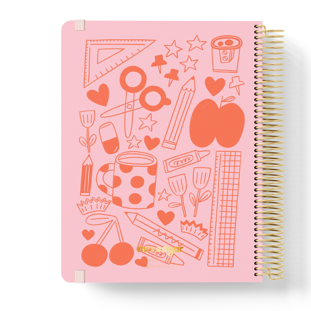 2026 teacher planner with a pink cover featuring playful red school-themed doodles like pencils, rulers, mugs, and hearts