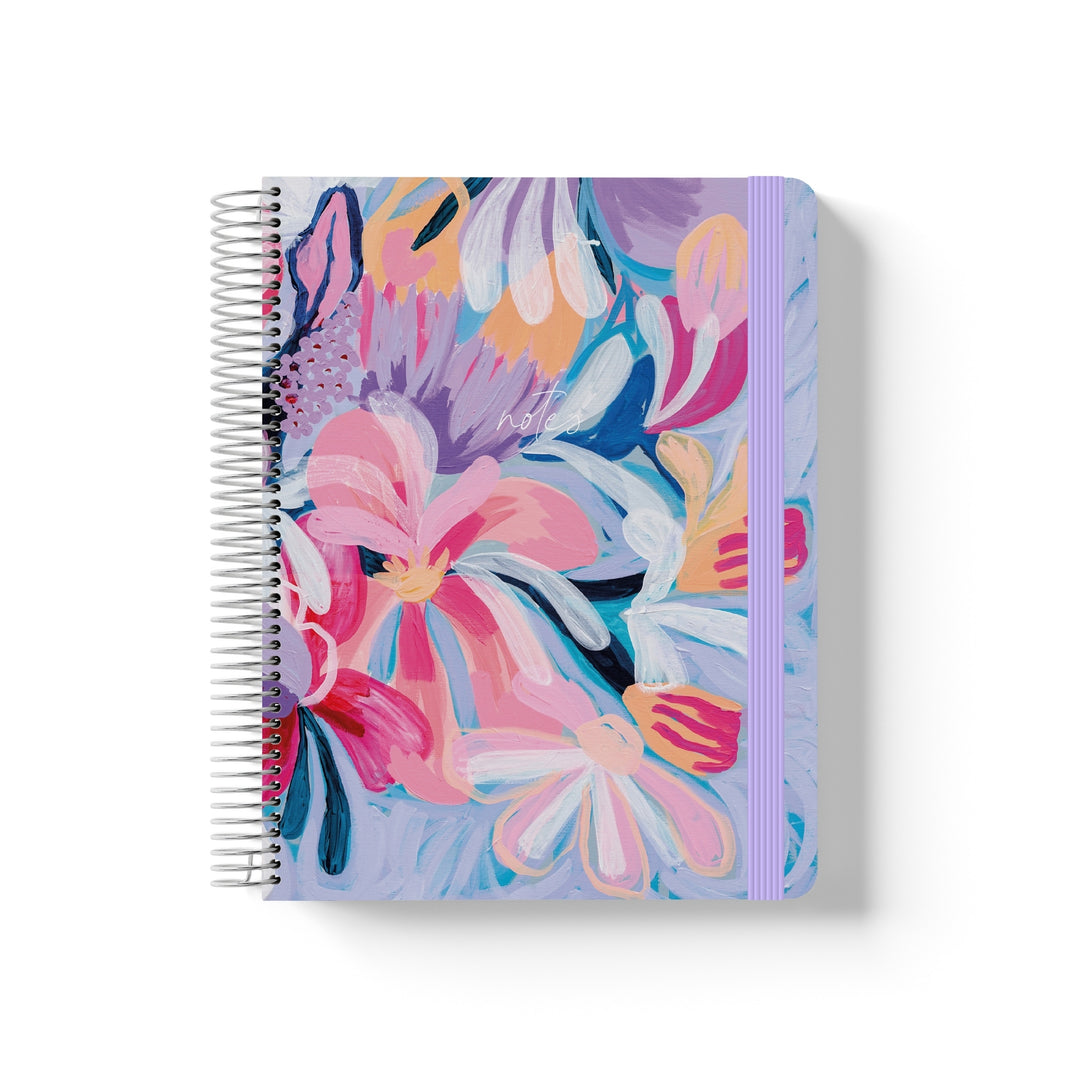 Coiled notebook with lilac elastic band and bold painted floral cover in pink, purple, orange, and blue with “notes” text.