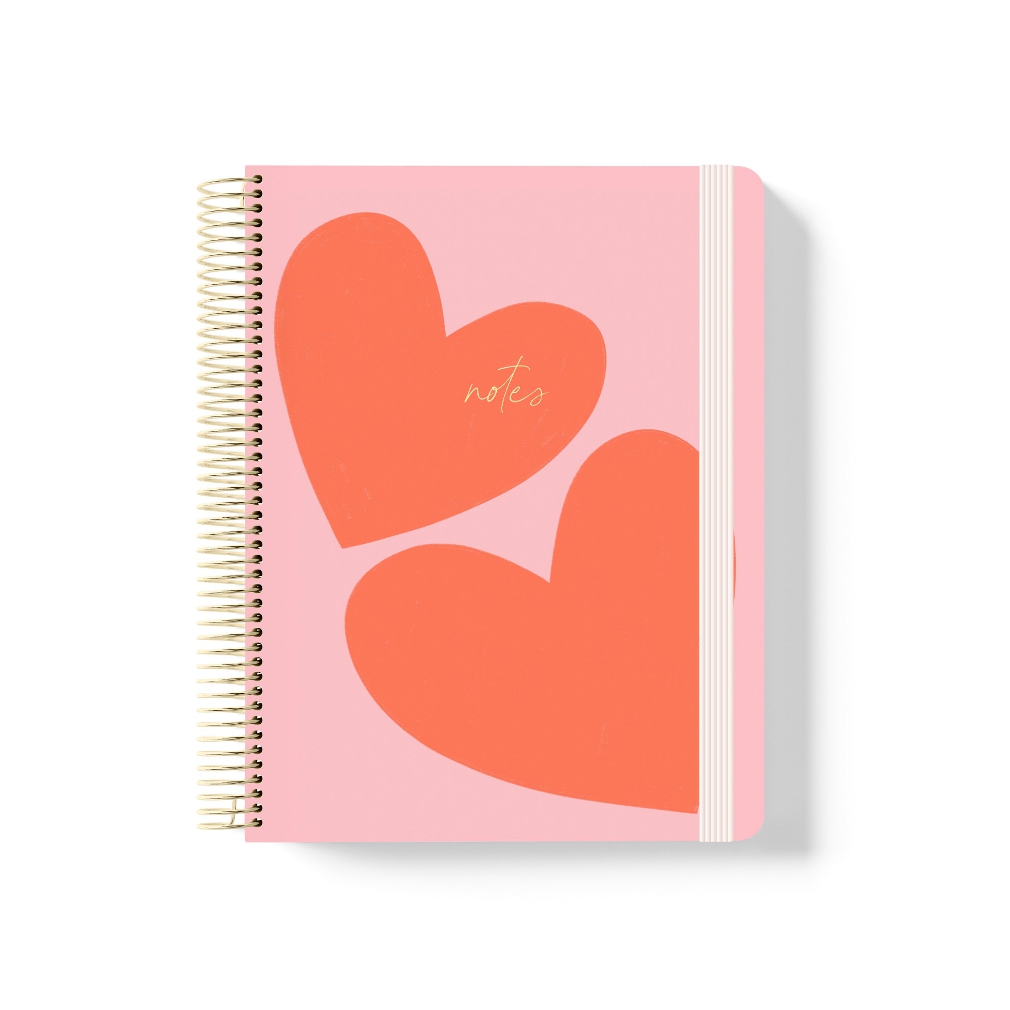 Pink coiled notebook with two large red hearts, gold “notes” script, gold spiral binding, and a pale pink elastic band.
