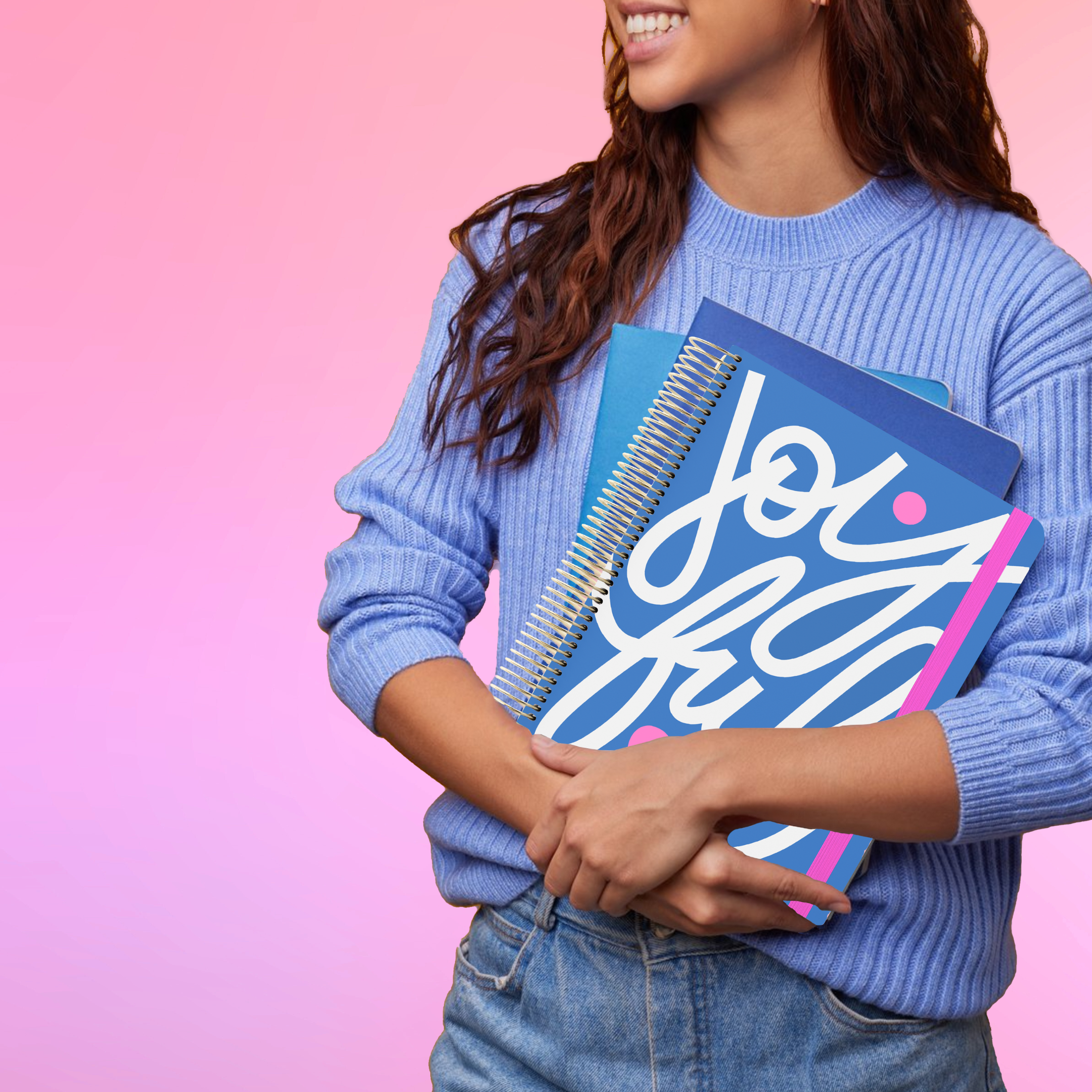 Smiling woman in a blue sweater holds the 2026 teacher planner with a blue cover and the text 'joyful' printed in big bold font.