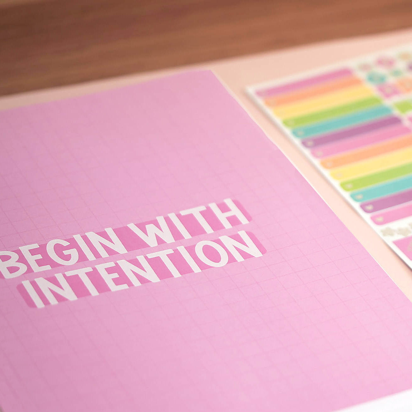 2027 Classic Weekly Teacher Planner Brights quote page — Begin With Intention on a pink grid, styled with rainbow sticker sheets
