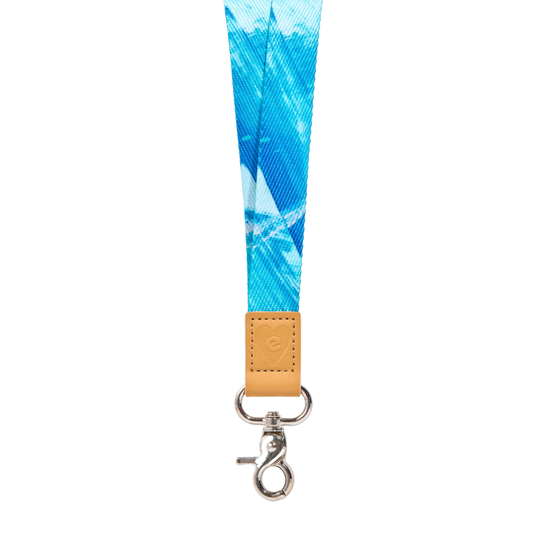 Blue fabric lanyard with gradient aqua tones, tan leather tab with embossed heart logo, and silver clasp, isolated on a clean white background