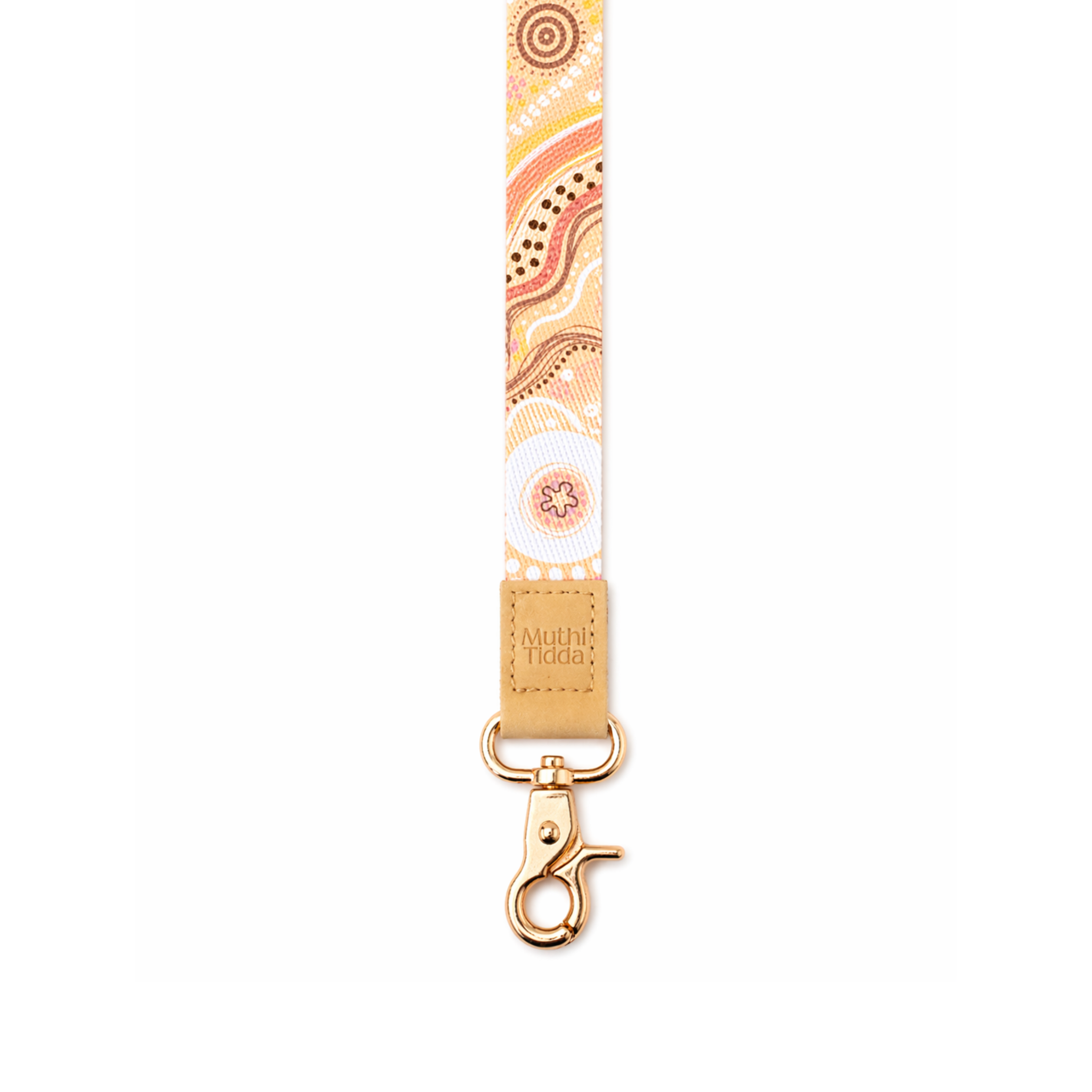 Cream and pastel patterned fabric lanyard with Indigenous-inspired dot artwork, tan leather logo patch, and gold clasp on a clean white background.