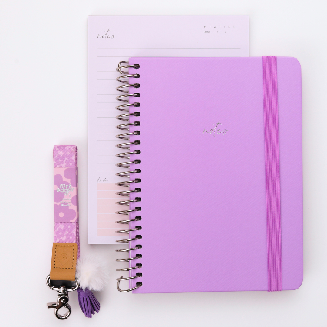 Lilac A5 teacher notebook with matching elastic band and soft patterned lanyard styled alongside a lined notepad