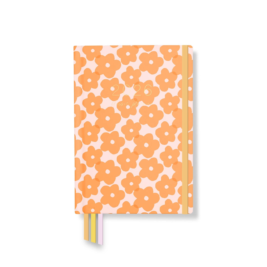 2026 classic planner front cover with a peach background and bold orange floral pattern, orange elastic closure, and pastel ribbon markers.