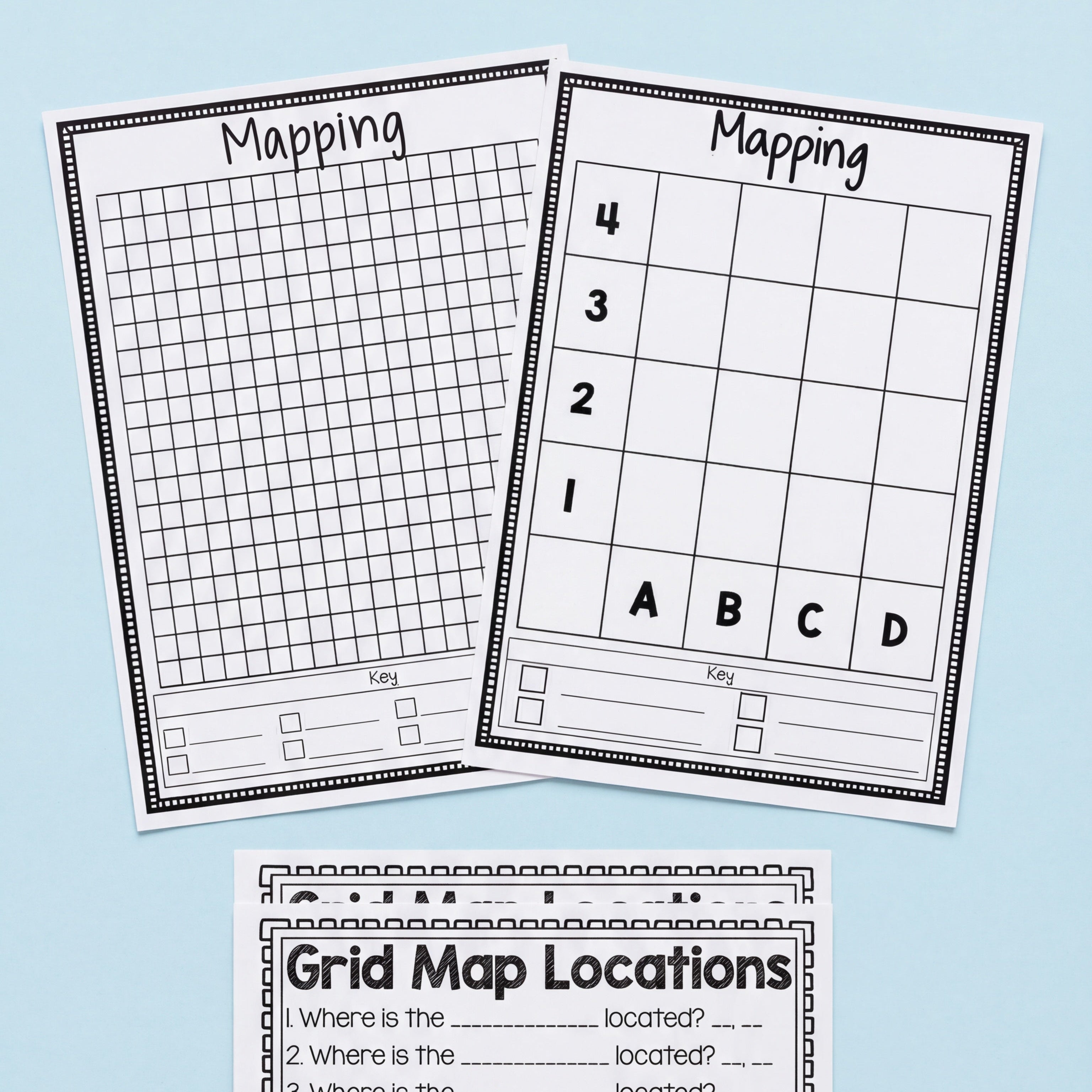 Three printable worksheets for grid mapping activities, including a 4x4 grid, a large detailed grid, and a 'Grid Map Locations' sheet with space to record coordinates and answers. Decorative classroom elements like colourful pom-poms, hearts, and googly eyes are scattered at the bottom for a creative touch
