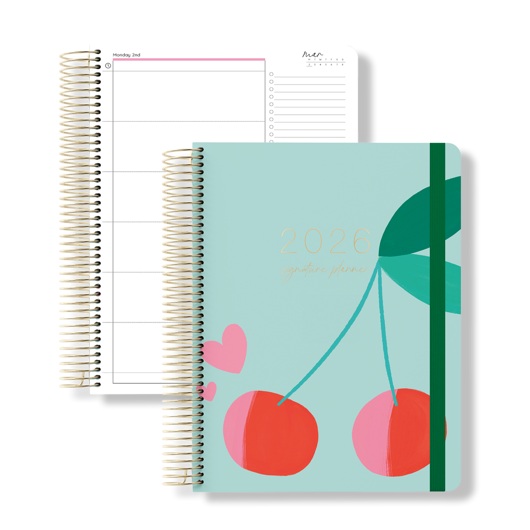 2026 daily teacher planner with bold cherry and leaf design on a teal cover, shown beside an open daily planning page.