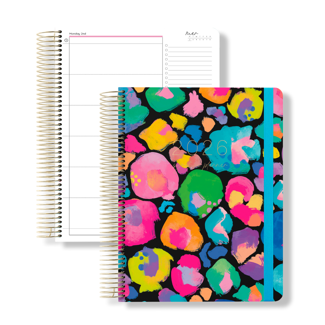 2026 daily teacher planner with a bold rainbow leopard print cover and blue elastic, shown next to an open daily planning page.