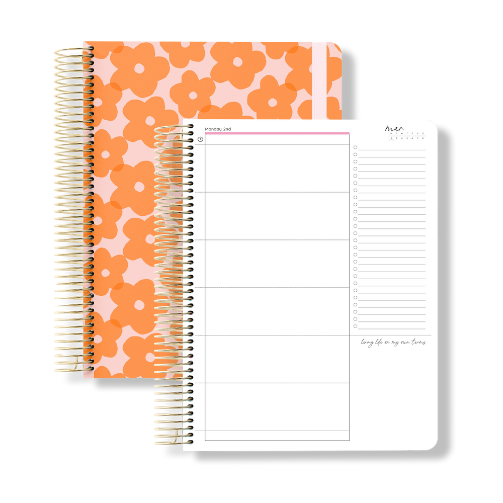 2026 daily teacher planner with bold orange floral pattern on a pink cover and white elastic, beside an open daily layout.