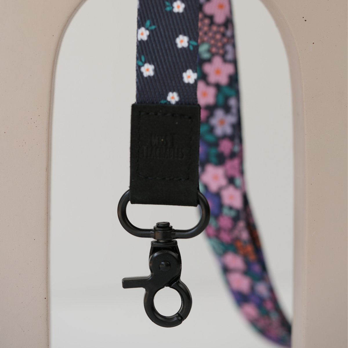 Detail of Dark Ditsy Floral reversible lanyard showing both navy floral and white daisy sides