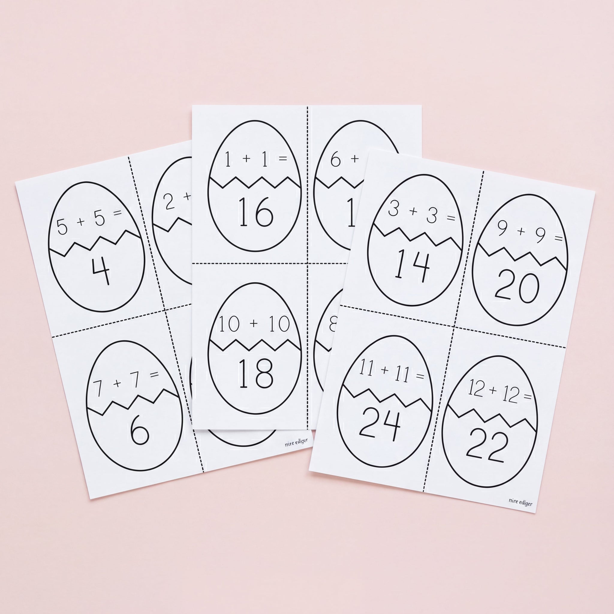 Set of Easter egg-shaped math problem cards on a pink background