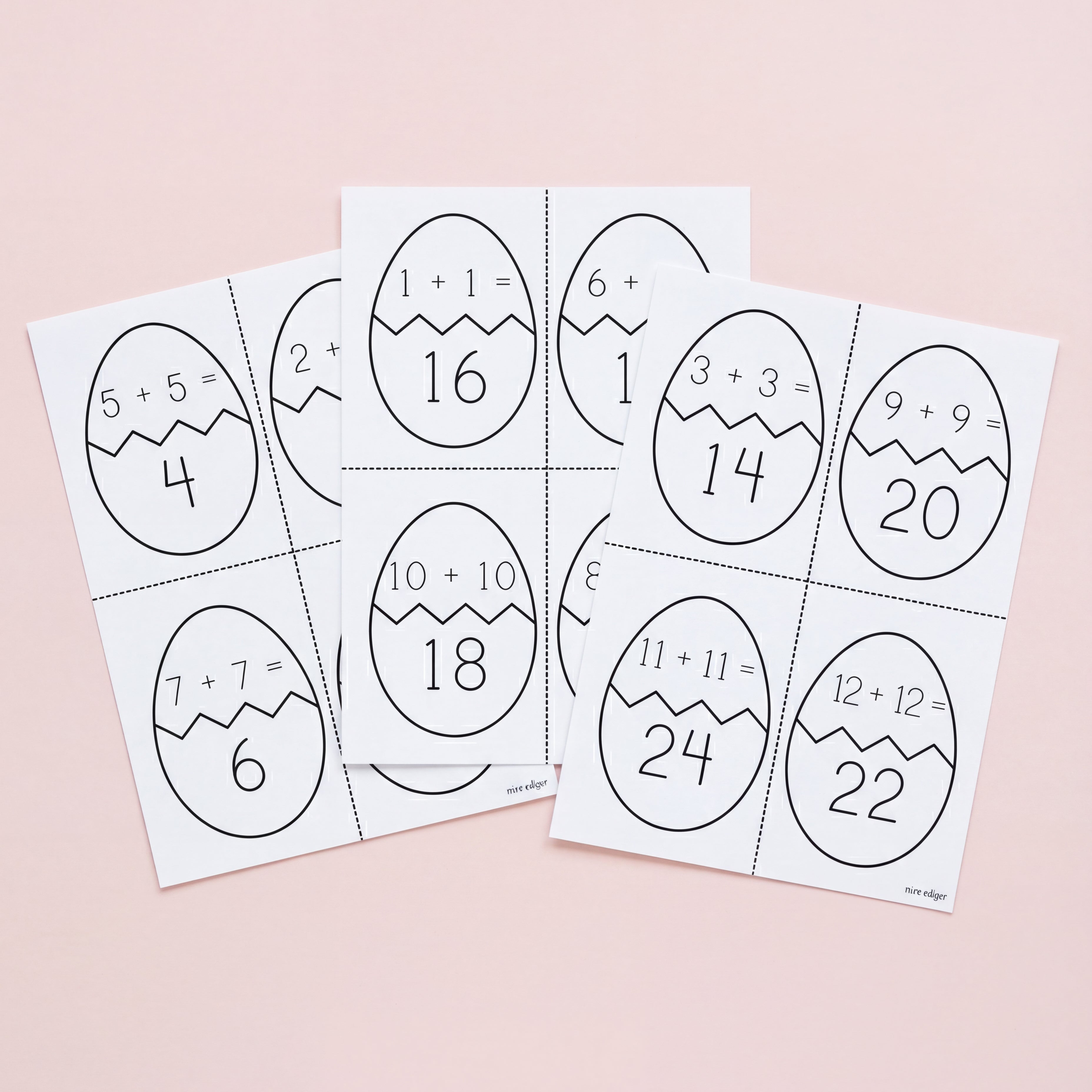 Set of Easter egg-shaped math problem cards on a pink background