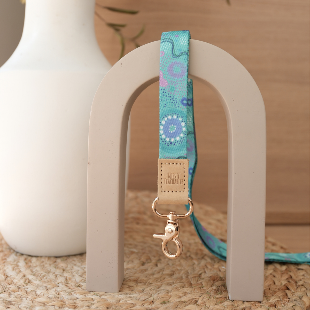 Inner Child teacher lanyard by Muthi Tidda, turquoise and violet dot artwork with tan leather tab and gold clasp