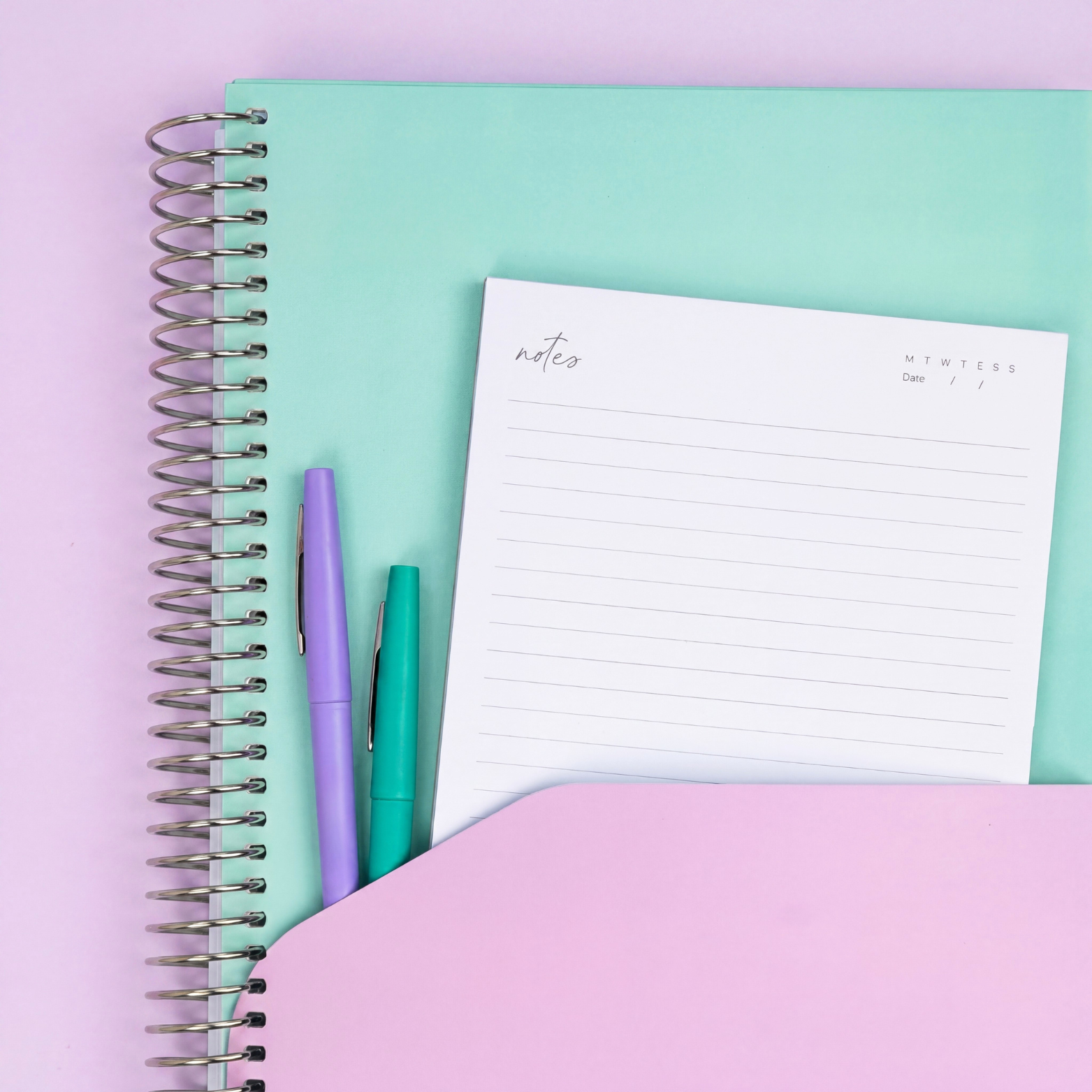 2027 Seafoam Signature Planner showing pink pocket sleeve with notes page and purple and teal pens, silver coil on lilac.