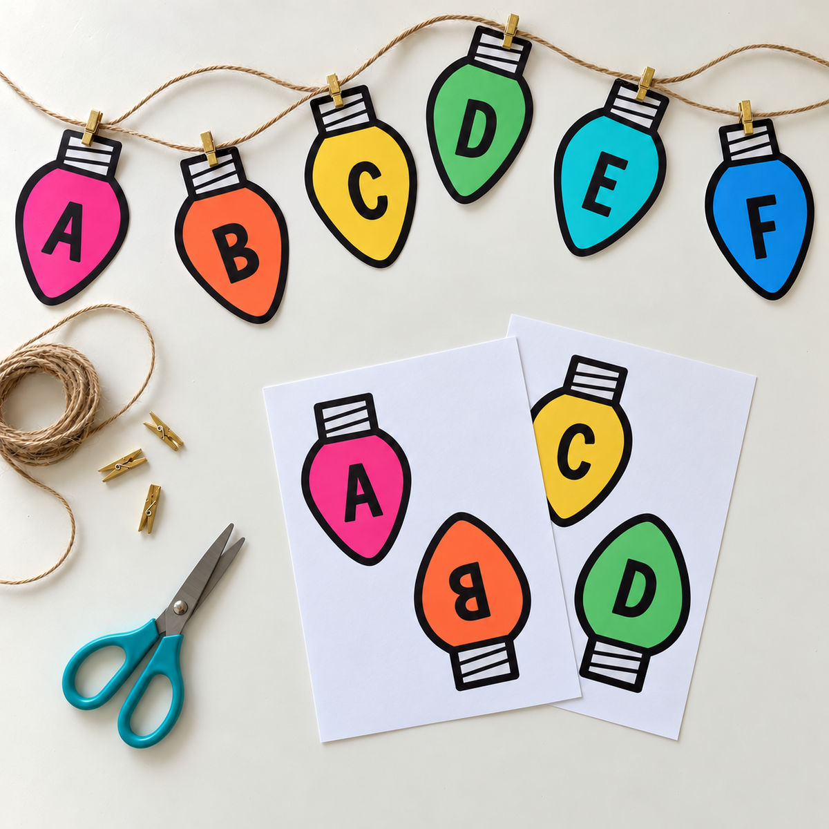 Rainbow Christmas light-bulb bunting letters being cut out and strung on a classroom craft table
