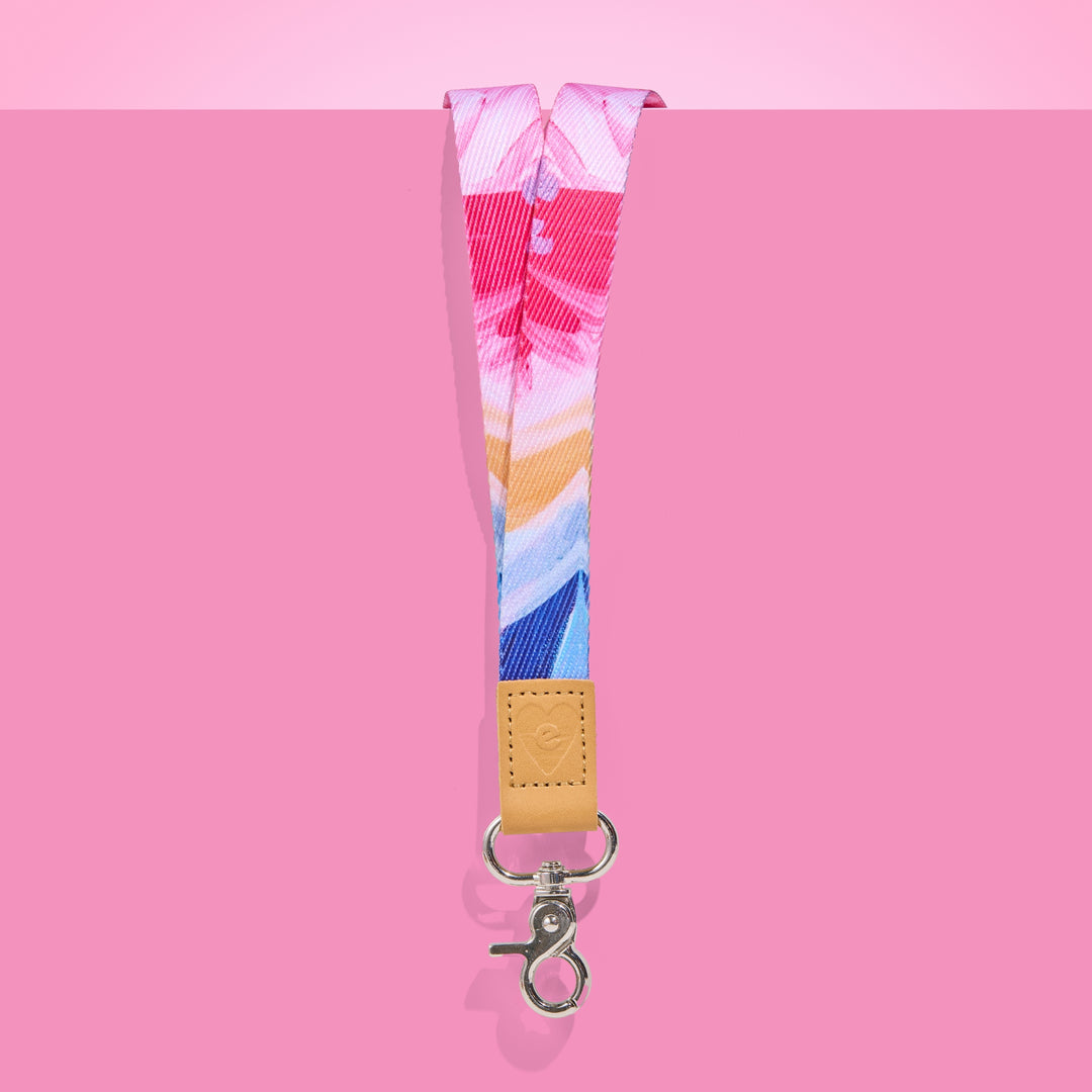 Colourful abstract teacher lanyard with shades of pink, blue and gold, featuring tan leather accent and silver clasp on a pink background.