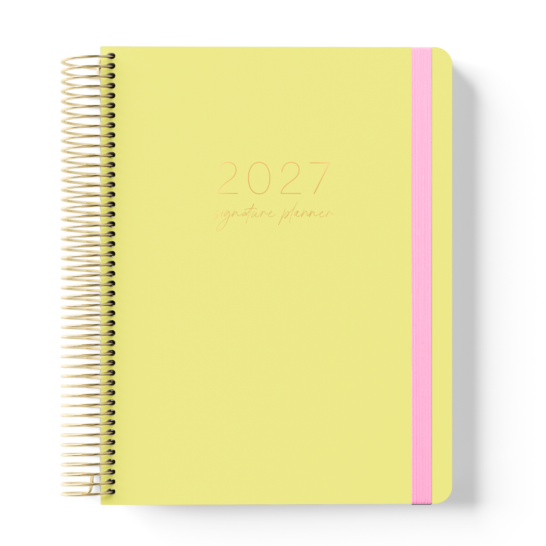 2027 Signature Daily Planner in Butter with tonal text on a soft yellow cover, gold coil binding, and pink elastic closure.