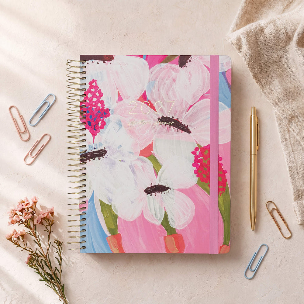 2027 Signature Planner in Petals styled with dried florals and colourful paper clips, gold coil and pink elastic closure.