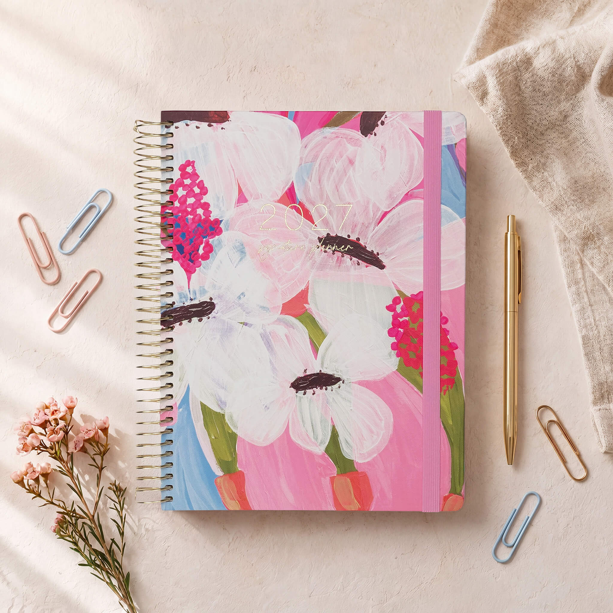 2027 Signature Planner in Petals styled with dried florals and colourful paper clips, gold coil and pink elastic closure.