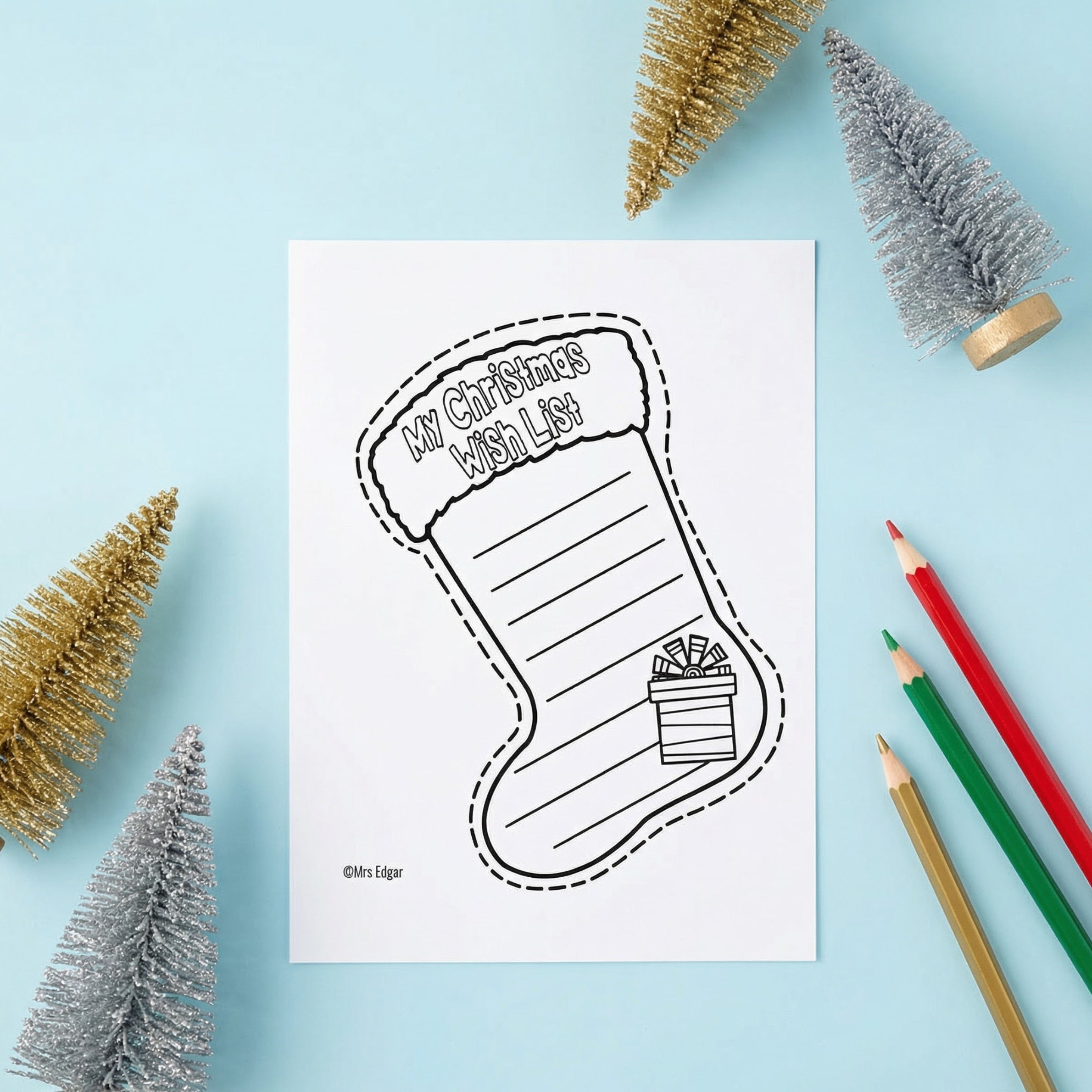 Printable Christmas stocking worksheet titled “My Christmas Wish List” with lines for students to write their wishes. The page is styled on a blue background with coloured pencils and small decorative Christmas trees.