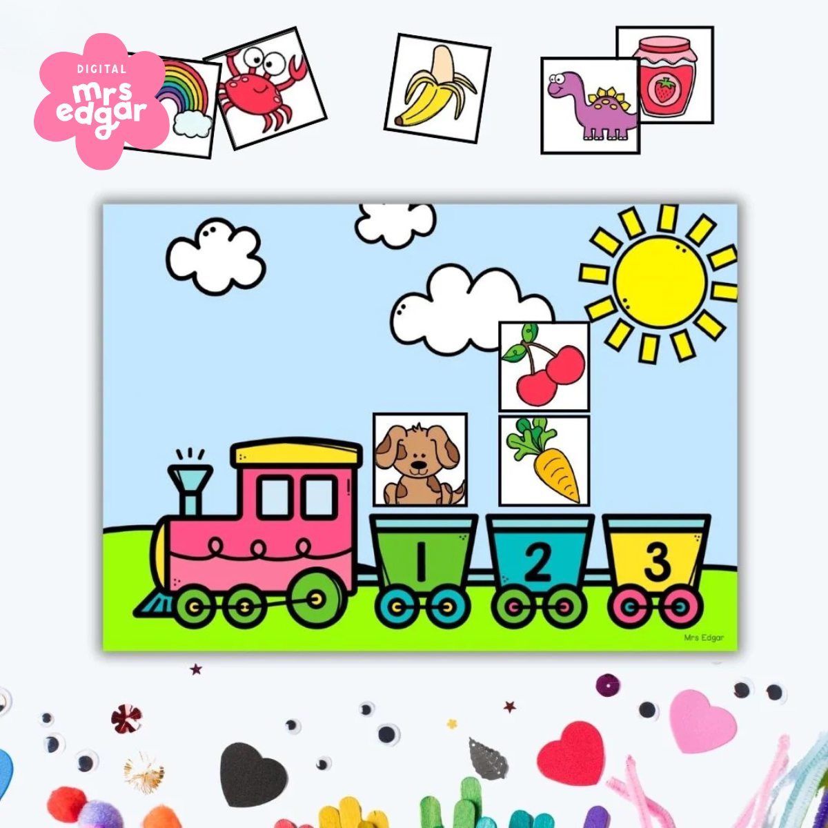 Brightly coloured train graphic with carriages numbered 1 to 4, set against a sunny background with clouds and a green field. Displayed amongst other decorative craft items.
