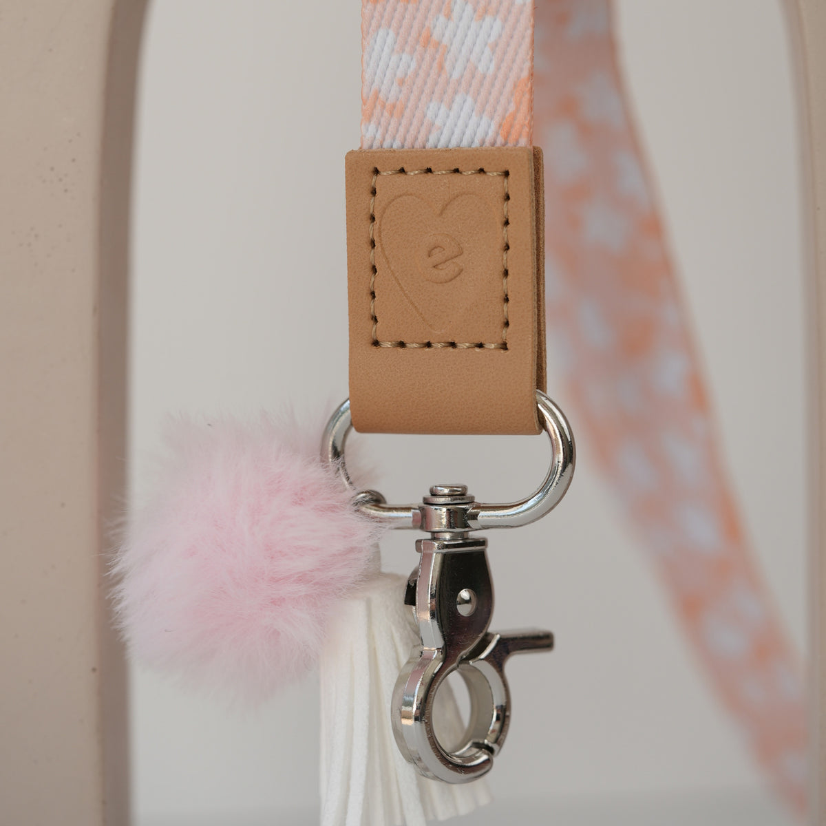 Detail of Boom teacher lanyard breakaway clasp, gold hardware with black pom pom and hot pink tassel