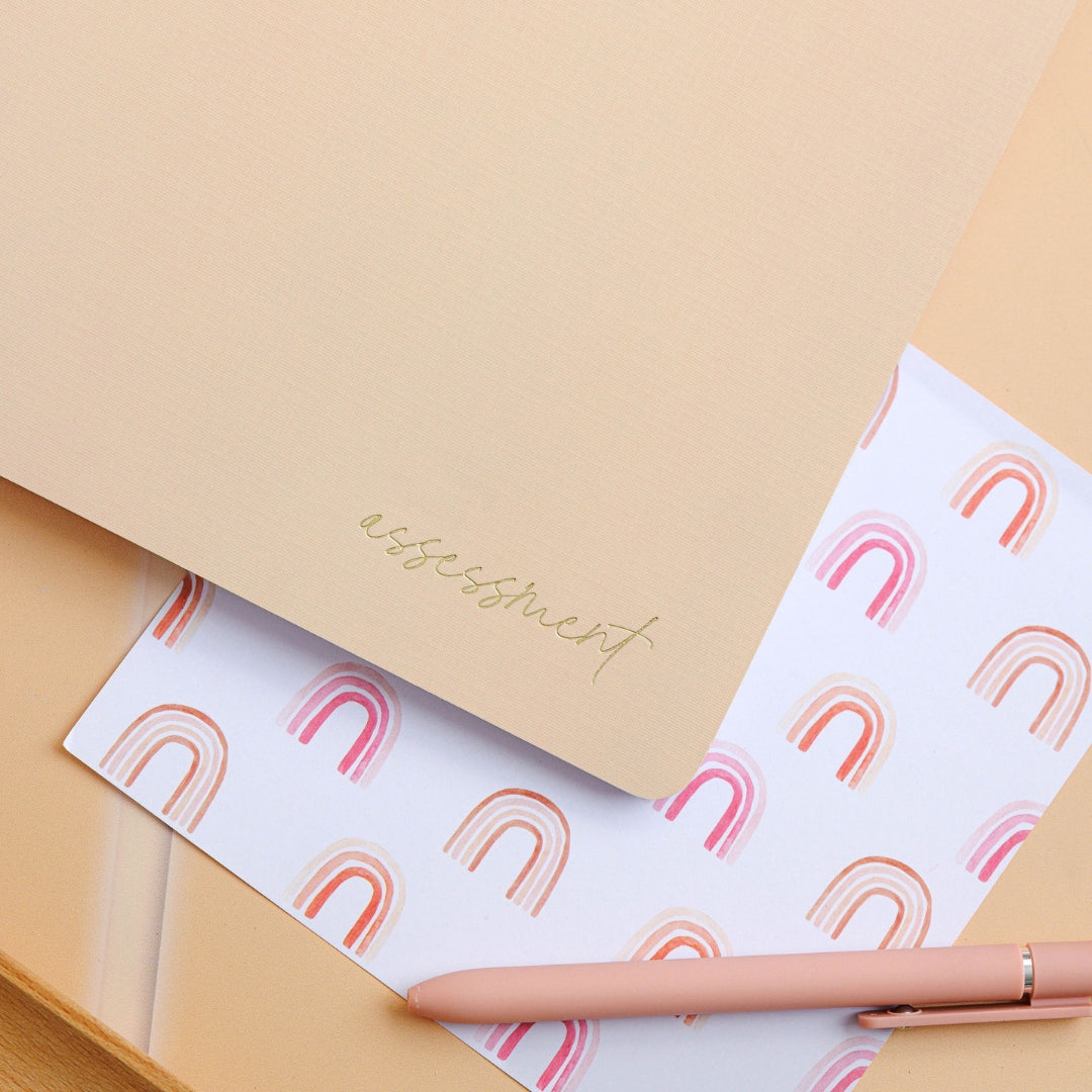 Tan assessment journal placed on a decorative surface, showcasing its elegant design.