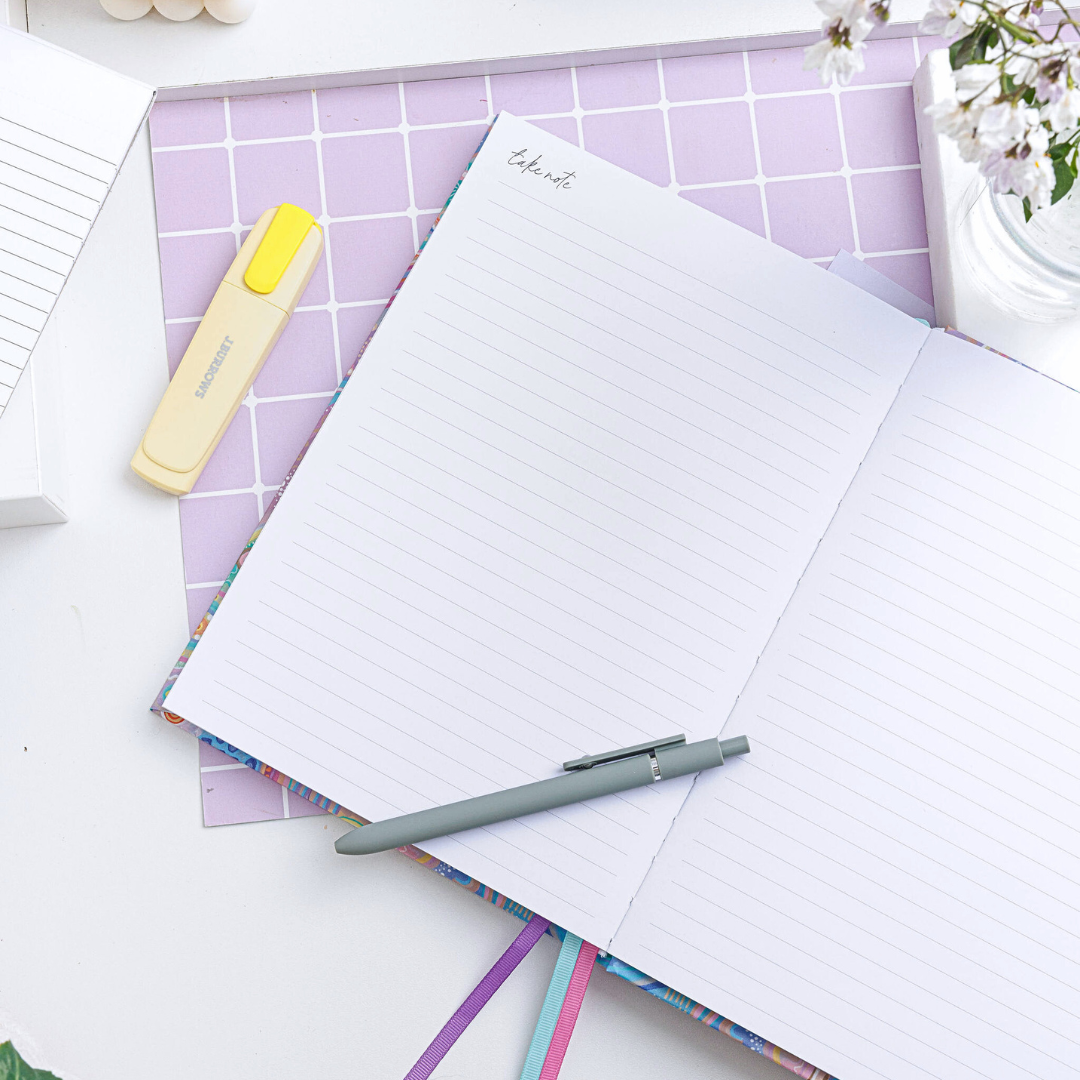 Open personal planner showing lined notebook pages on both sides, with 'Take Notes' written at the top left and a pen resting on the pages.