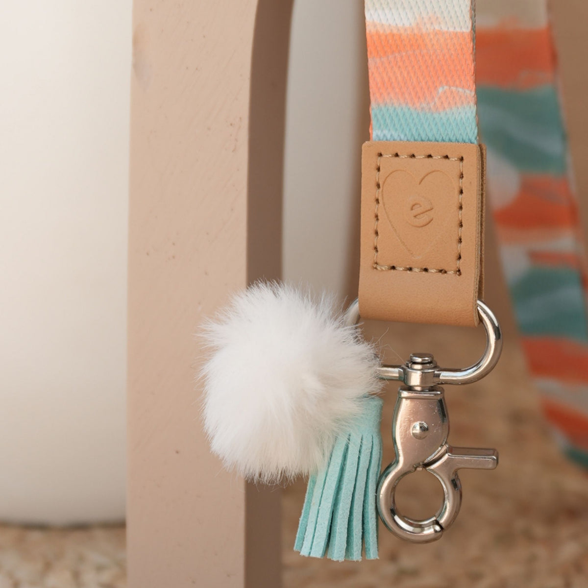 Close up of Dreamy Afternoon teacher lanyard, silver clasp, white pom pom and mint tassel