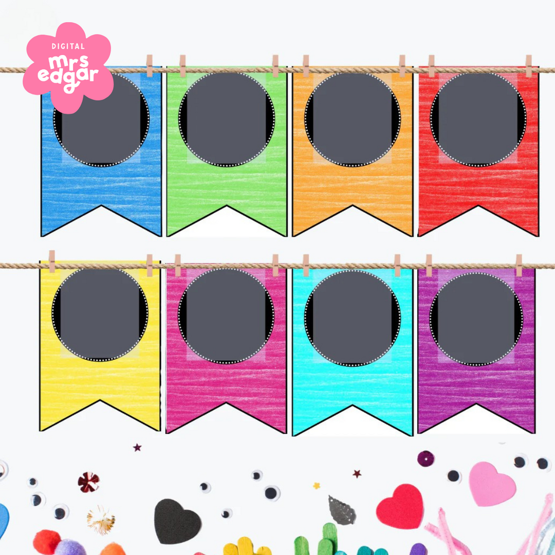  A cheerful rainbow-colored pennant banner with chalkboard-style black circles for customisable letters or icons. Displayed on string with mini pegs and surrounded by classroom decorations like pompoms, hearts, and googly eyes.
