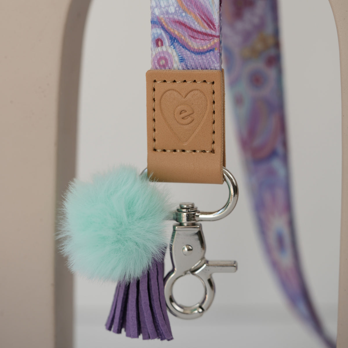 Detail of Jewels teacher lanyard breakaway clasp, silver hardware with deep blue pom pom and orange tassel