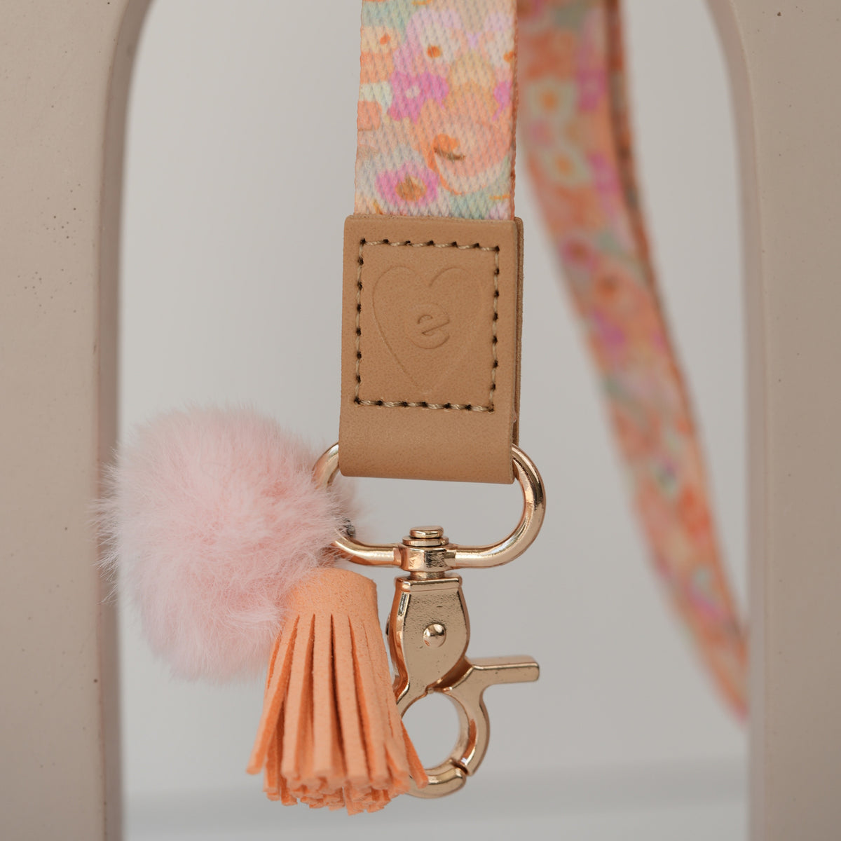 Detail of Olive Branches teacher lanyard clasp, silver hardware with white pom pom and mint tassel