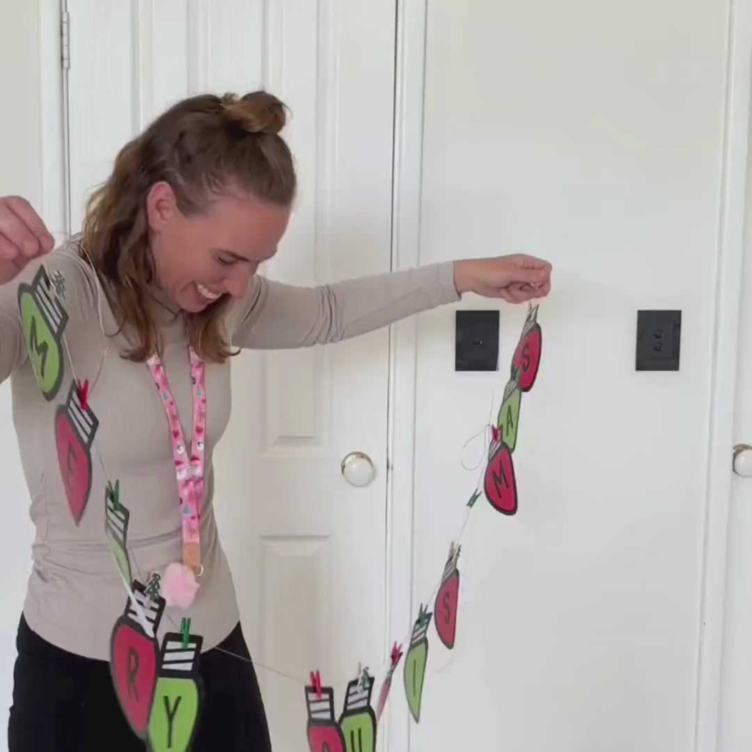 Video of the printable Christmas bunting letters being cut out and pegged onto string to spell Merry Christmas.