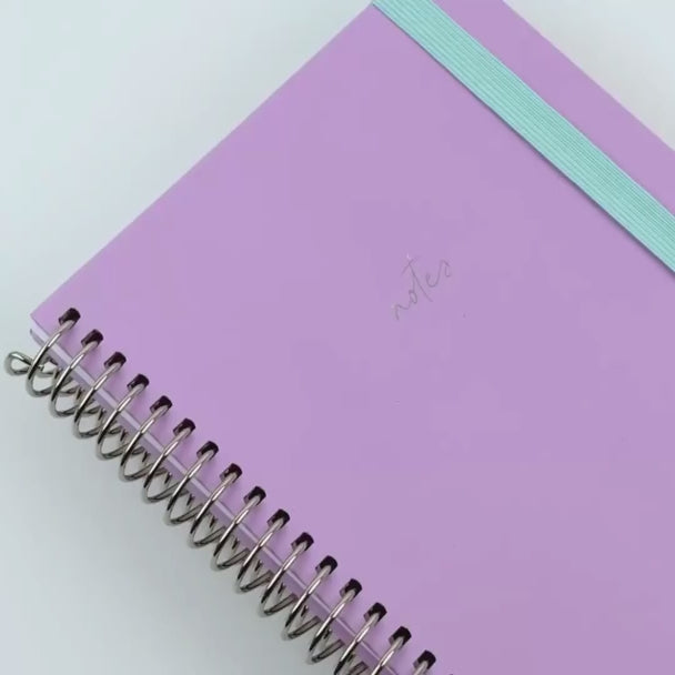 lilac notebook shown off with teal elastic and sliver binding