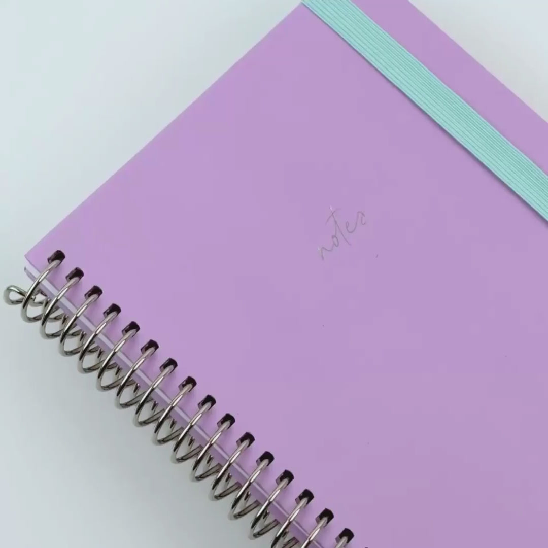 lilac notebook shown off with teal elastic and sliver binding