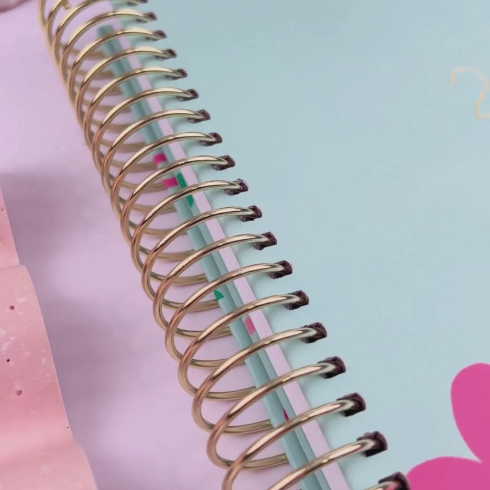Front and back covers of the 2026 mint cherries teacher planner being showcased on a white desk in a hands-on video demonstration.