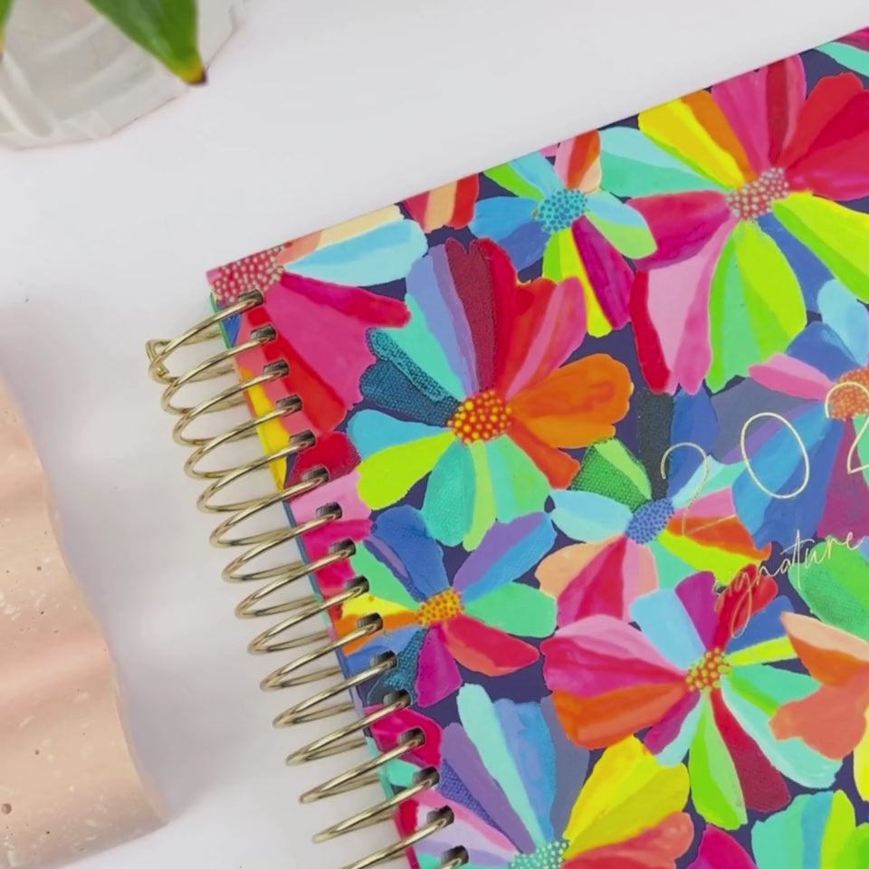 Front and back covers of the 2026 Petal Party teacher planner being showcased on a white desk in a hands-on video demonstration.
