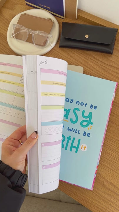 Woman showcasing the bright internal pages of the 2025 Classic Weekly Teacher Planner 'Snow Drift' highlighting its layout and features.