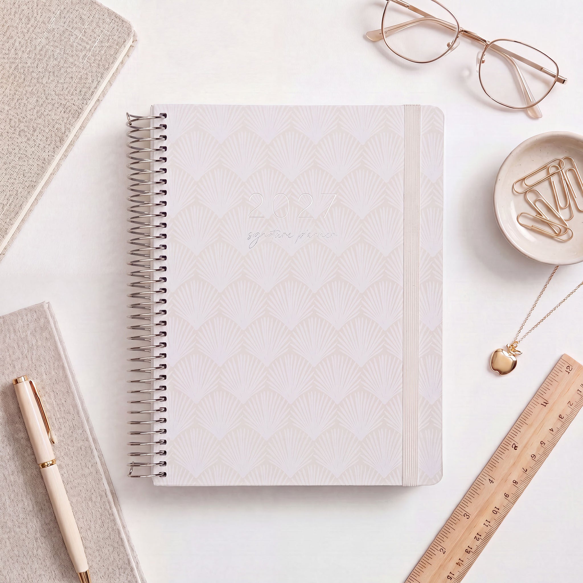 2027 Signature Planner in Shells styled with gold glasses and a wooden ruler, silver coil and cream elastic closure.