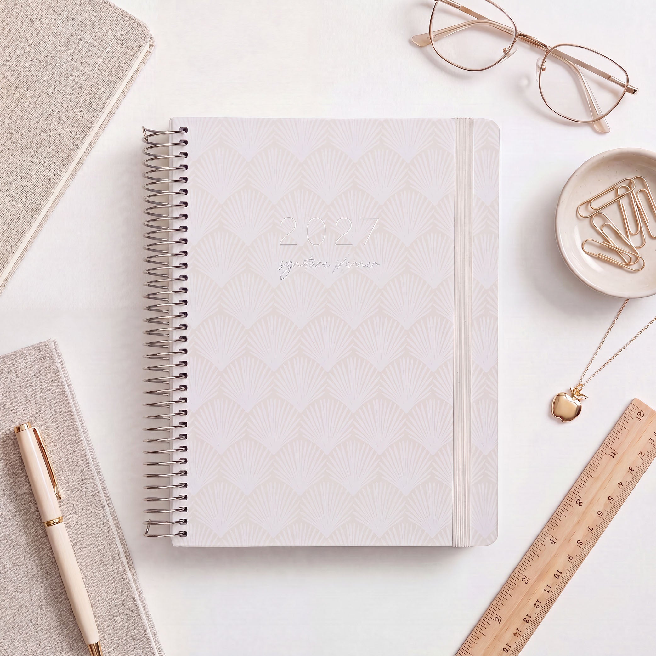 2027 Signature Planner in Shells styled with gold glasses and a wooden ruler, silver coil and cream elastic closure.