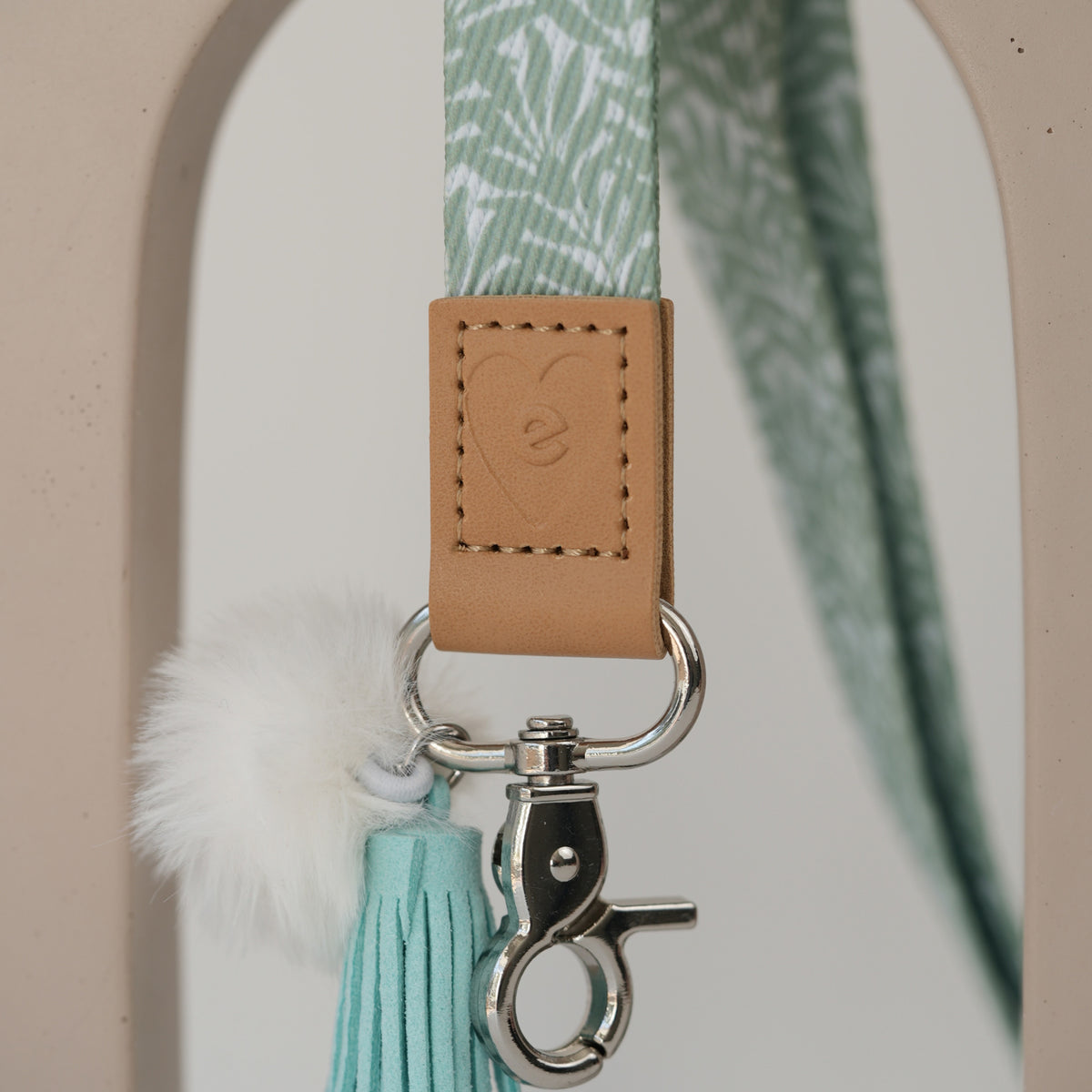Detail of So Sweet teacher lanyard breakaway clasp, silver hardware with peach pom pom and white tassel