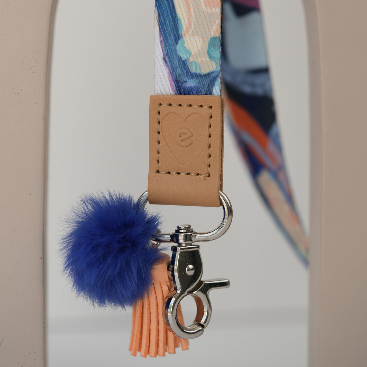Detail of Sunburst Golden teacher lanyard clasp, gold hardware with white pom pom and orange tassel