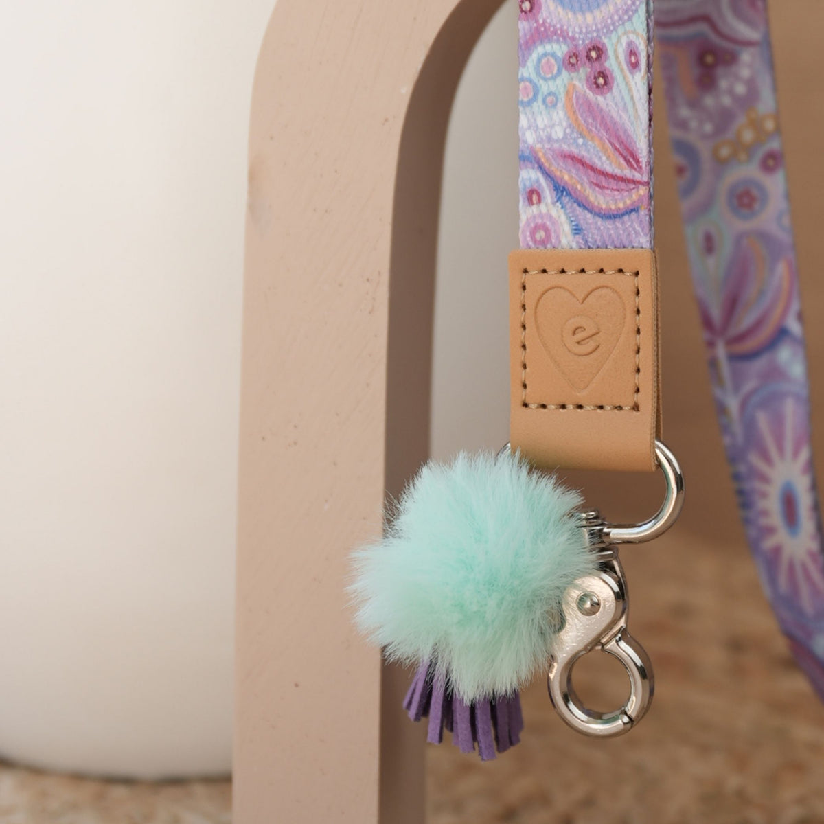 Close up of Walking With the Stars teacher lanyard artwork, silver clasp, mint pom pom and lilac tassel